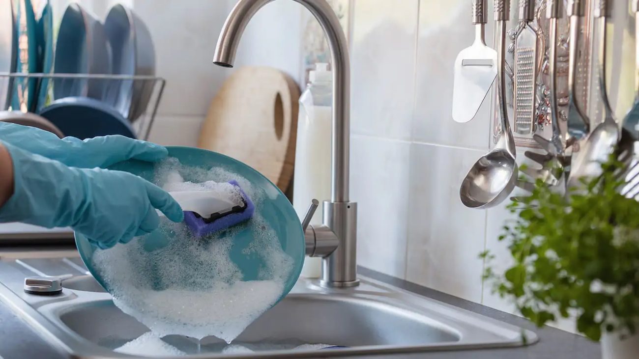 Mujer lavando platos.